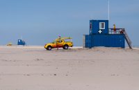 lifeguard-stepping-into-yellow-pickup-truck-on-dutch-beach_t20_NxmVOE
